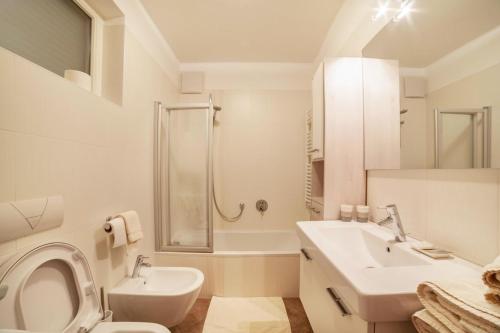 La salle de bains blanche est pourvue d'un lavabo et de toilettes. dans l'établissement Truma Swing Small And Cozy, à Merano