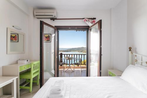 a bedroom with a bed and a balcony at Theoxenia Apartments in Ormos Panagias