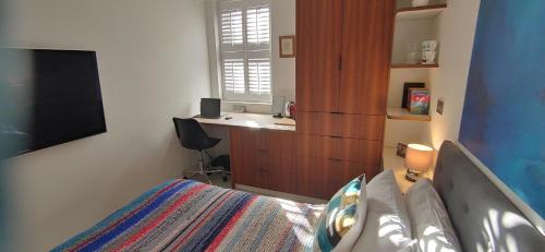 a bedroom with a bed and a sink and a desk at Comfortable Room With Ensuite in London