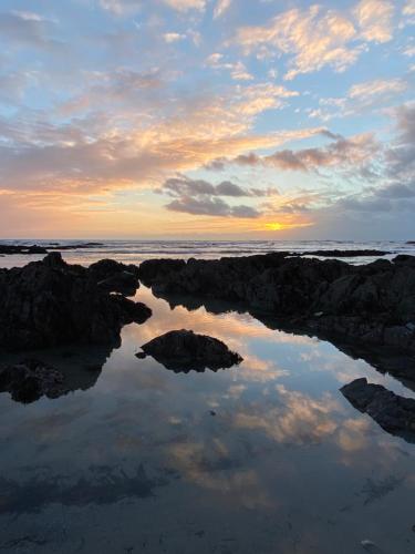 a reflection of the sunset in a body of water at Cosy double room in a seaside cottage in Crafthole