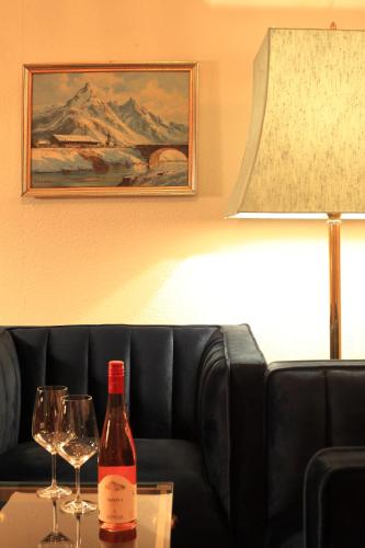 a bottle of wine sitting on a table with two wine glasses at Hotel Askania 1927 in Bad Wiessee