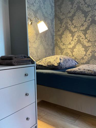 a bedroom with a bed and a dresser and a lamp at MISVEST Tomasz Klimatyzacja in Zabrze