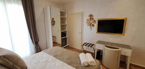 a bedroom with a bed and a desk and a television at Amsterdam Suite Hotel & SPA in Rimini