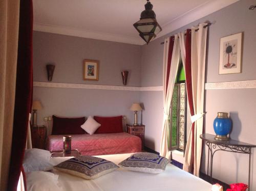 a bedroom with two beds and a window at Riad Syba in Marrakech