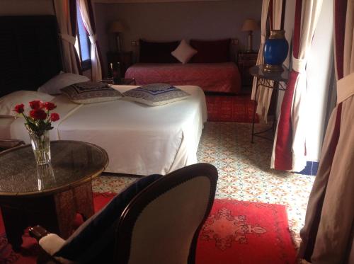 a bedroom with a bed and a table and chairs at Riad Syba in Marrakech