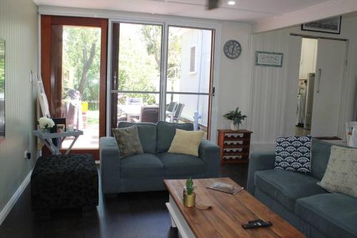 a living room with two couches and a coffee table at Little Ray on Sunshine. Hamptons style beachhouse in Woorim