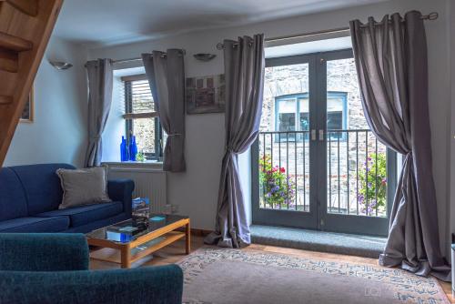 uma sala de estar com um sofá azul e janelas em The Duplex by Pureserviced em Plymouth