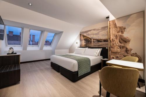 a hotel room with a bed and a table and chairs at Eurostars Ambassador in Budapest