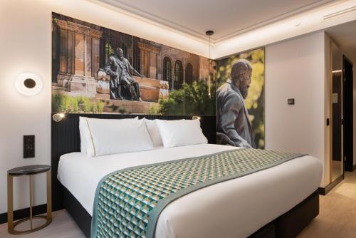 a bedroom with a bed with a painting on the wall at Eurostars Ambassador in Budapest
