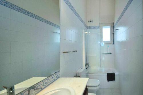 uma casa de banho branca com um lavatório e um WC em Sleep y Stay Duplex Barri Vell em Girona