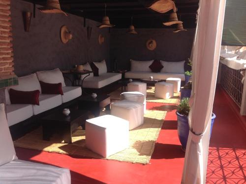 a room with white couches and tables on a balcony at Riad Syba in Marrakech