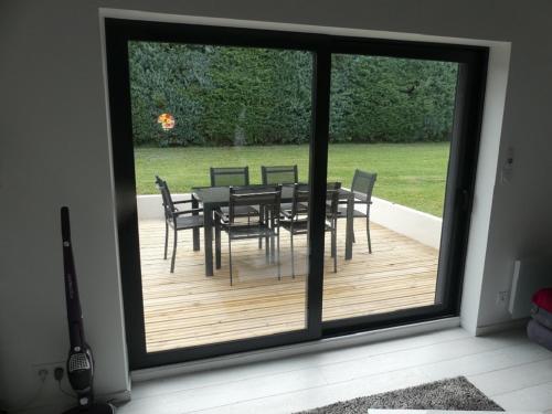 a sliding glass door with a table and chairs at Appartement 30 m2 neuf + terrasse in Brindas