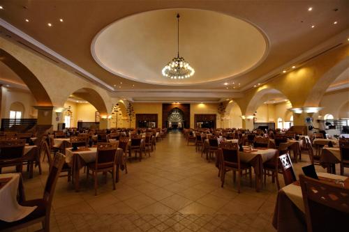 une salle à manger avec des tables et des chaises ainsi qu'un lustre dans l'établissement Zita Beach Resort, à Zarzis