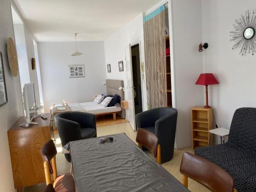 un salon avec une table et des chaises et une chambre dans l'établissement Logis B21, à Rochefort