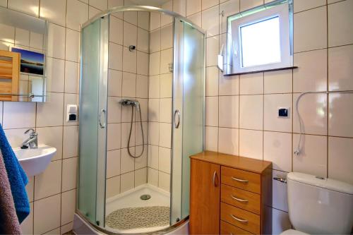 a bathroom with a shower and a toilet and a sink at Domek Twórczy Kąt in Święta Katarzyna