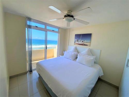 a bedroom with a bed with a view of the ocean at Cozumel 311 in Umdloti