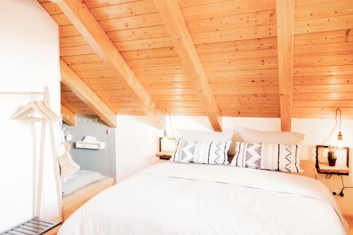 Schlafzimmer mit einem weißen Bett und Holzdecken in der Unterkunft Sohana Lifestyle Apartments I Stefan's Home I Rust in Rust