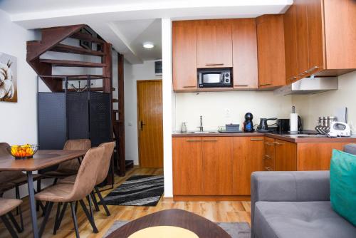 a kitchen and a living room with a table in a room at Apartman Lily in Brzeće