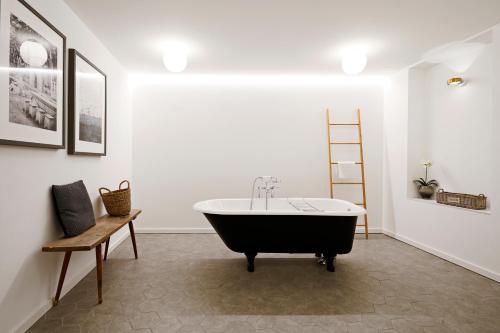 a bathroom with a bath tub and a chair at numa I Nora Apartments in Salzburg