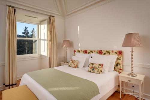 a white bedroom with a large bed and a window at Hotel Casa Palmela - Small Luxury Hotels of The World, Hotel & Villas in Setúbal