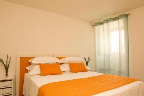 a bedroom with a bed with orange and white pillows at Hotel Casa Palmela - Small Luxury Hotels of The World, Hotel & Villas in Setúbal