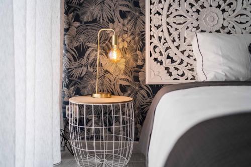 a lamp on a table next to a bed in a bedroom at HOME@abrantes in Abrantes