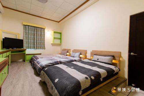 関山鎮にあるBethel Homestayのベッド2台と薄型テレビ付きのベッドルーム