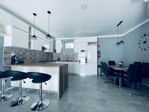 a kitchen with a counter and stools in a room at Thermal Family in Makó