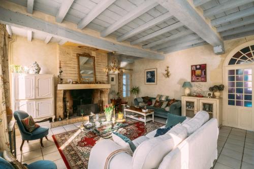 a living room with a white couch and a fireplace at La Maison 64 Chambre D'Hôtes in Barbaste
