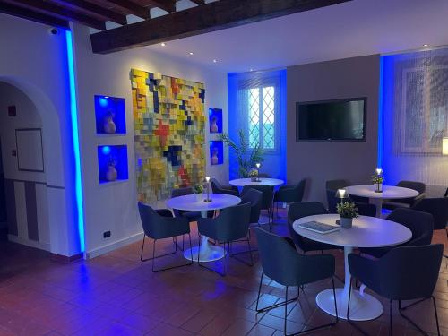a restaurant with tables and chairs in a room with blue lights at Albergo Ligabue in Gualtieri