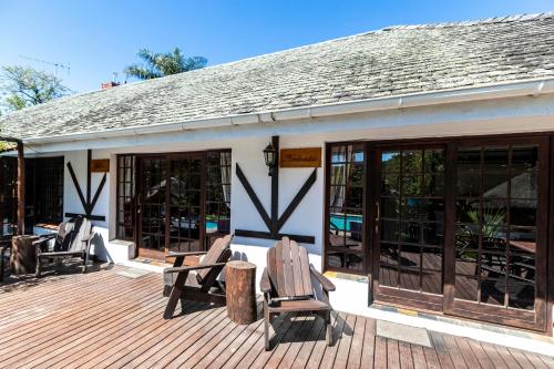 a deck with rocking chairs on a house at Fish Eagle Manor in East London
