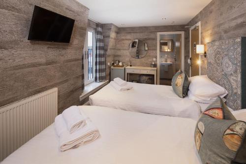 a hotel room with two beds and a television at Hotel Hebrides in Tarbert