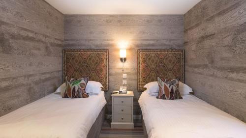 two twin beds in a room with two lamps at Hotel Hebrides in Tarbert