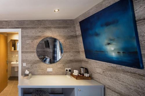 baño con lavabo y espejo en la pared en Hotel Hebrides en Tarbert