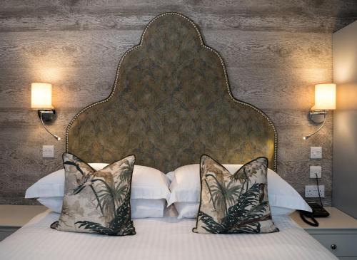 a bedroom with a bed with a large headboard and pillows at Hotel Hebrides in Tarbert