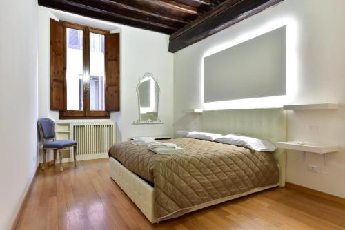 a bedroom with a bed and a chair and windows at Elite Rome apartments 2 in Rome
