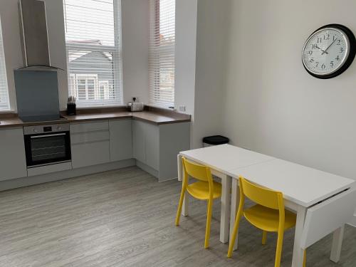 a kitchen with a table and chairs and a clock at Kings Cross by Pureserviced in Plymouth