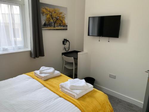 a bedroom with a bed and a flat screen tv at Kings Cross by Pureserviced in Plymouth