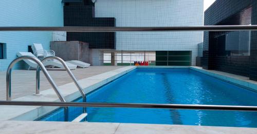 uma piscina num edifício ao lado de um edifício em Residencial Amazonia Apto 1205 em João Pessoa