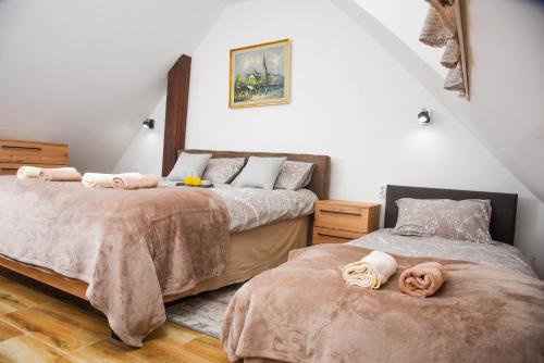 a bedroom with two beds with towels on them at Apartman Lily in Brzeće