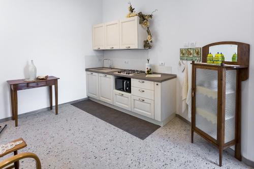 La cuisine est équipée de placards blancs et d'un four avec plaques de cuisson. dans l'établissement Da Pina e Quinto Home, à Morciano di Romagna