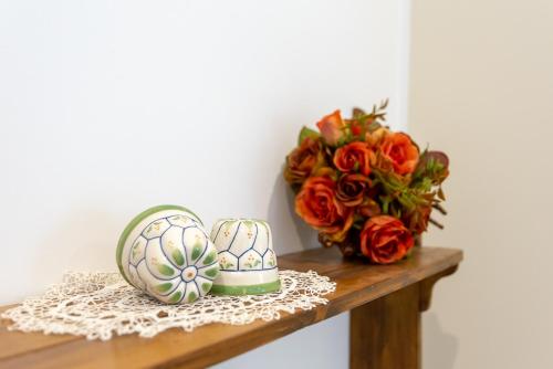 a shelf with a bouquet of roses and a easter egg at Da Pina e Quinto Home in Morciano di Romagna