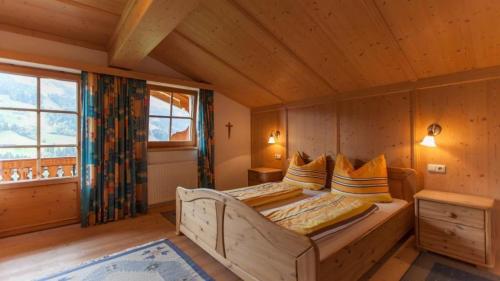 a bedroom with a bed in a wooden room at Außermoos-Zuhaus in Alpbach