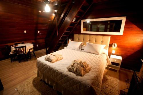 1 dormitorio con 1 cama con 2 toallas en Pousada Alpes, en Santo Antônio do Pinhal