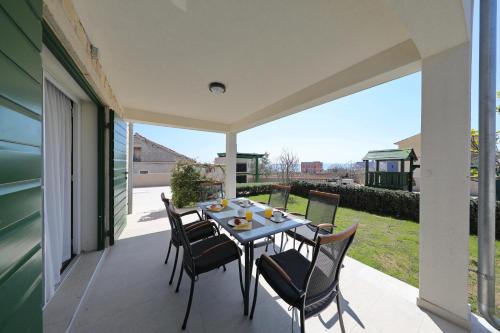 a table and chairs on the patio of a house at Corte villas & apartments - AE1043 in Privlaka