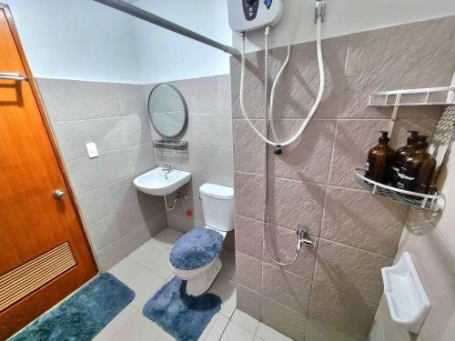 a bathroom with a shower and a toilet and a sink at Mesatierra Garden Residences in Davao City