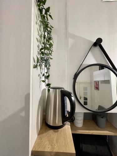 un miroir et une bouilloire sur une table dans l'établissement Le Cosy, charmant studio centre ville, à Rennes