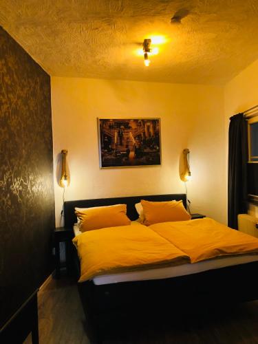 a bedroom with a bed with yellow sheets and pillows at Pension Winnemuller in Cochem