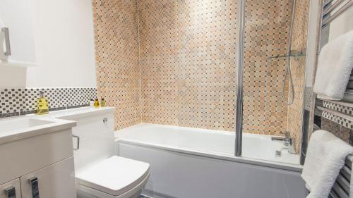 ein Bad mit einer Badewanne, einem WC und einer Dusche in der Unterkunft Captain's Quarters by Pureserviced in Plymouth
