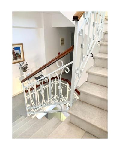 a staircase with a wrought iron rail and stair case at King A in Argostoli